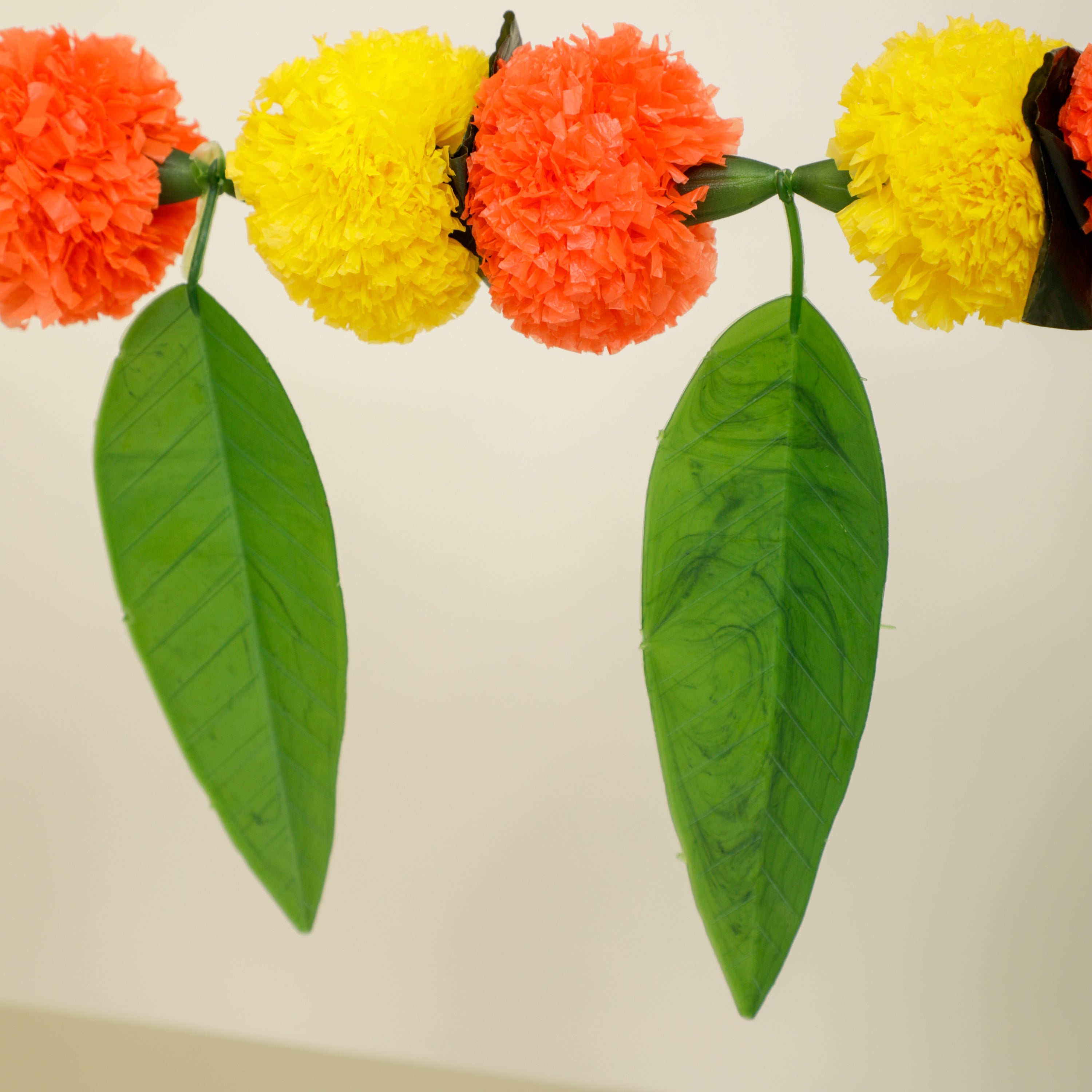 It features artificial marigold flowers and mango leaves that lend it an authentic appearance and texture